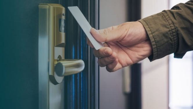 cilvēks atver viesnīcas durvis