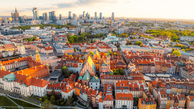 Skats no putna lidojuma uz Varšavas vecpilsētu, kur tālumā redzami debesskrāpji