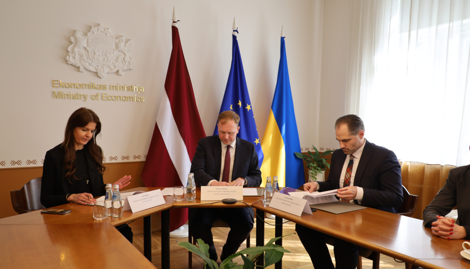 No kreisās puses pie galda sēž: LIAA direktore Ieva Jāgere, Ekonomikas ministrs Viktors Valainis un Lietuvas Transporta un loģistikas alianses Tarptautinio transporto ir logistikos aljansas ģenerālsekretārs Povilas Drižas